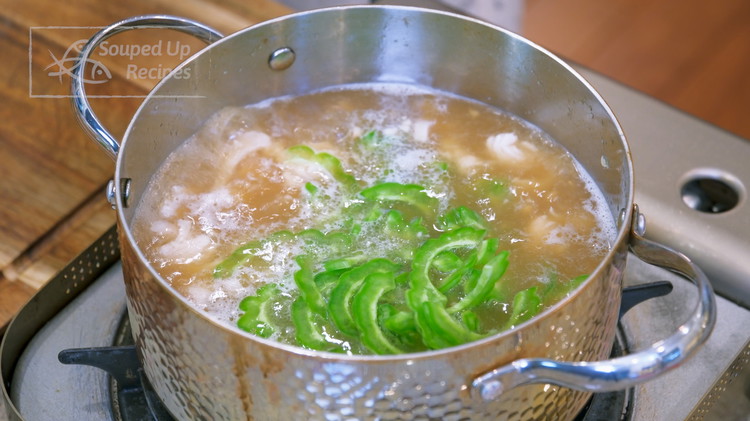 Image of It takes about 5 minutes for it to come to a boil over medium heat, which is just enough time to cut the bitter melon in half and use a spoon to remove the center part. Slice the bitter melon...