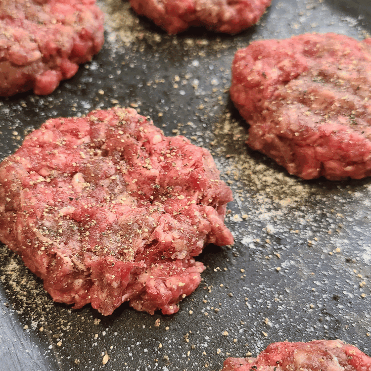Image of Divide the ground elk meat into 8 equal portions and shape them into patties. Season each patty generously with salt and pepper.