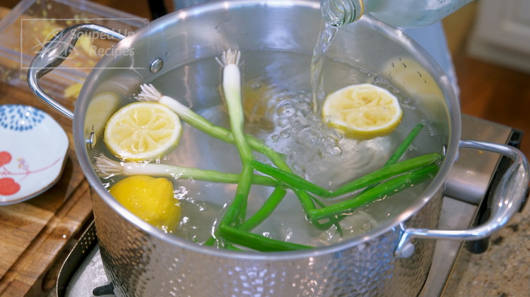 Image of Bring a big pot of water (3.5 Liters) to a boil. Add ginger slices, lemon scraps, scallions, and Chinese cooking wine.