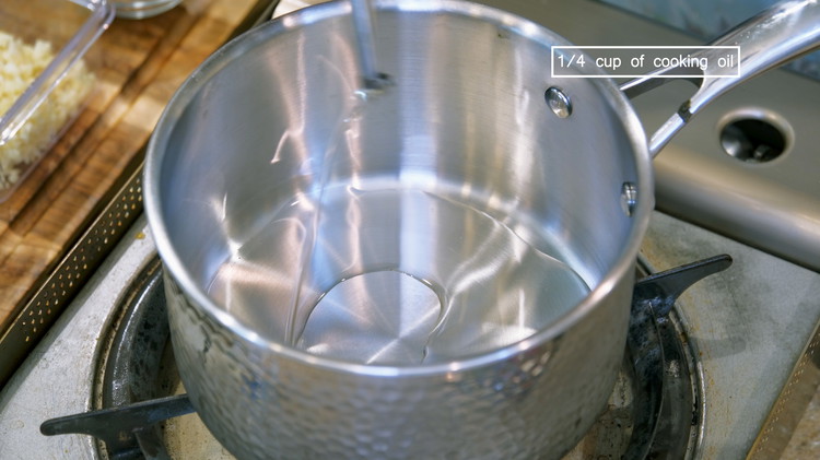 Image of In a saucepan, add cooking oil and heat it over medium heat for a minute. 