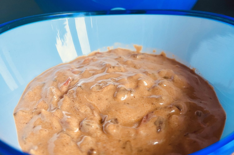 Image of Gib die zuvor zubereitete Spice Up, Zwiebel- und Tomatenmischung in die Schüssel mit dem Frischkäse und Honig. Vermische alles gründlich.
