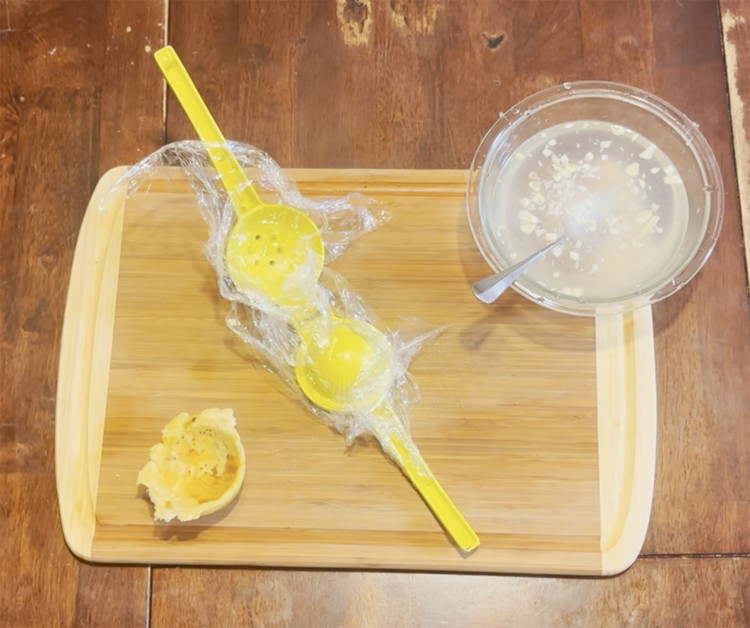Image of Place one of the fried pieces of plantains on top of the plastic wrap in the bowl side of the lemon squeezer. Close the lemon squeezer with the 2nd piece of plastic wrap on the other side and squeeze until...