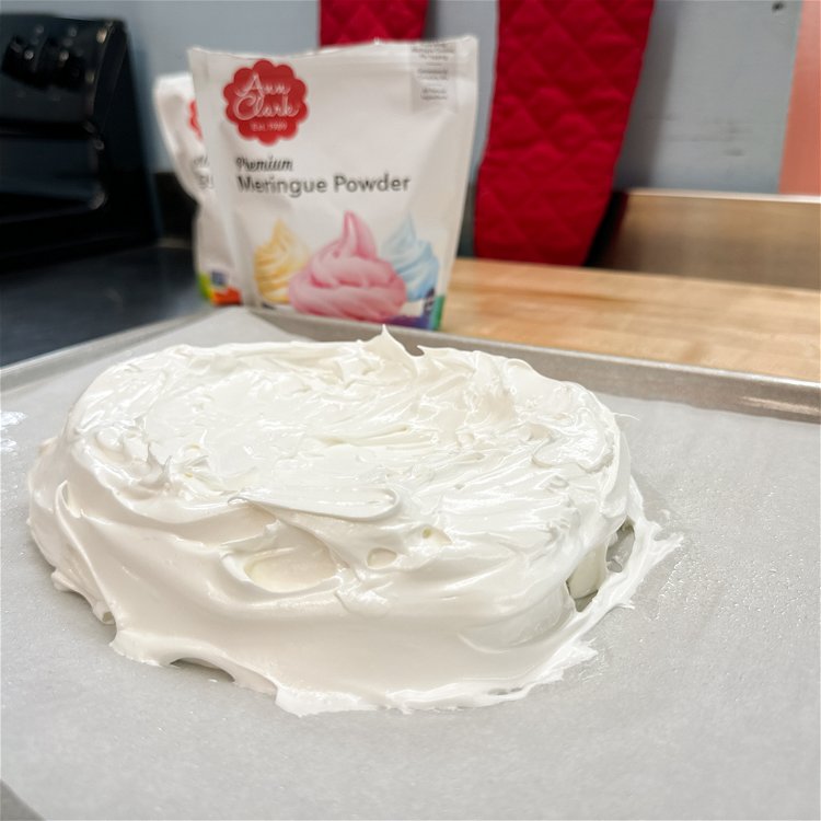 Image of Gently transfer the whipped meringue from the bowl onto a sheet prepared with parchment paper. Shape into a shallow bowl using a rubber spatula.