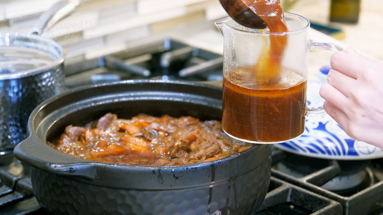 Image of Once the beef is done simmering, take the garlic bulbs and Thai bird-eye chilies out. Use a spoon to scoop out some of the braising liquid and set it aside because every stove and cookware differs. We have no idea...