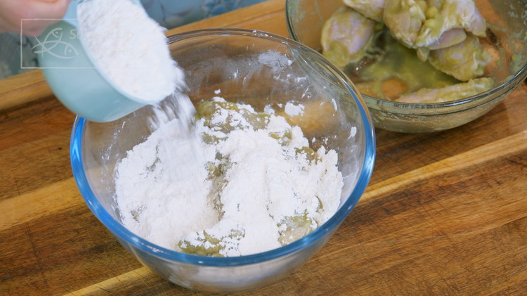 Image of Use a measuring cup to scoop out half of the flour mixture and reserve it on the side. Place the marinaded wings into the flour bed, then sprinkle the reserved flour to cover them. Put on the lid and shake...