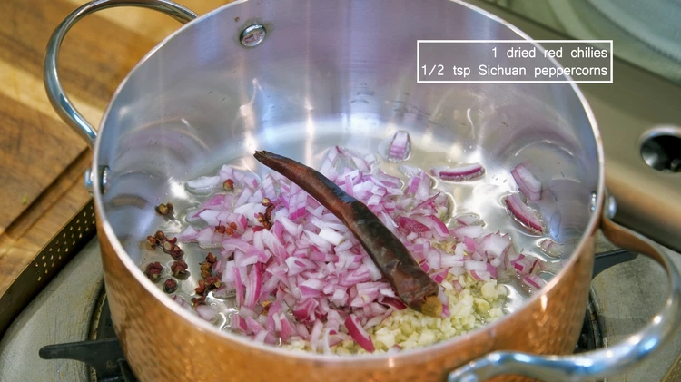 Image of Place a pot over a medium-heat stove and add oil, the diced shallot, garlic, and, optionally, dried red chili and Sichuan peppercorns. Stir for 2 minutes.