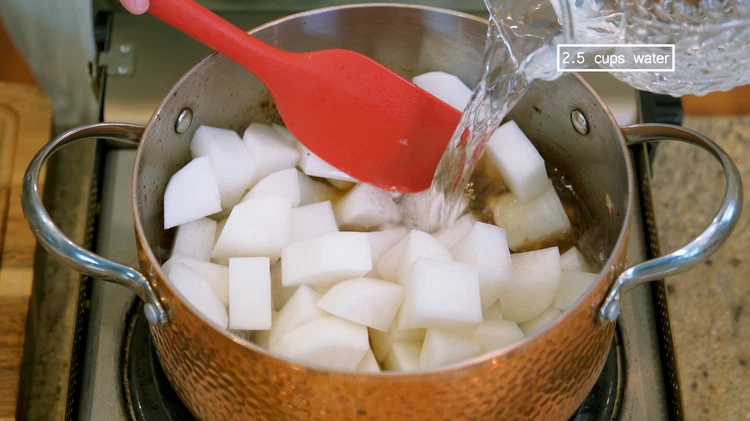 Image of Add the daikon radish and pour in 2.5 cups of water. You can use vegetable stock if you want. Bring the pot to a boil. Turn the heat to low and let it simmer for 25 minutes.