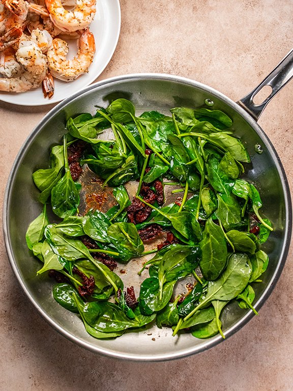 Image of Add sun dried tomatoes and baby spinach to skillet and...