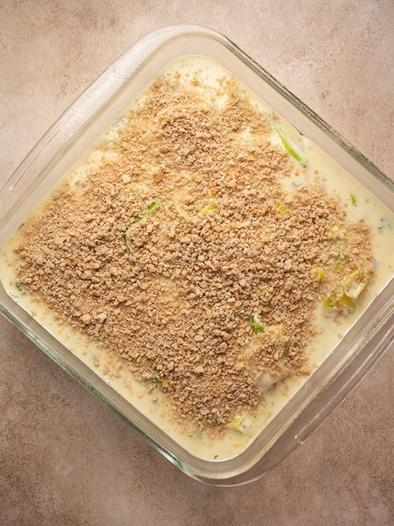 Image of Pour cheese sauce over halibut and sprinkle with breadcrumbs. Cover...