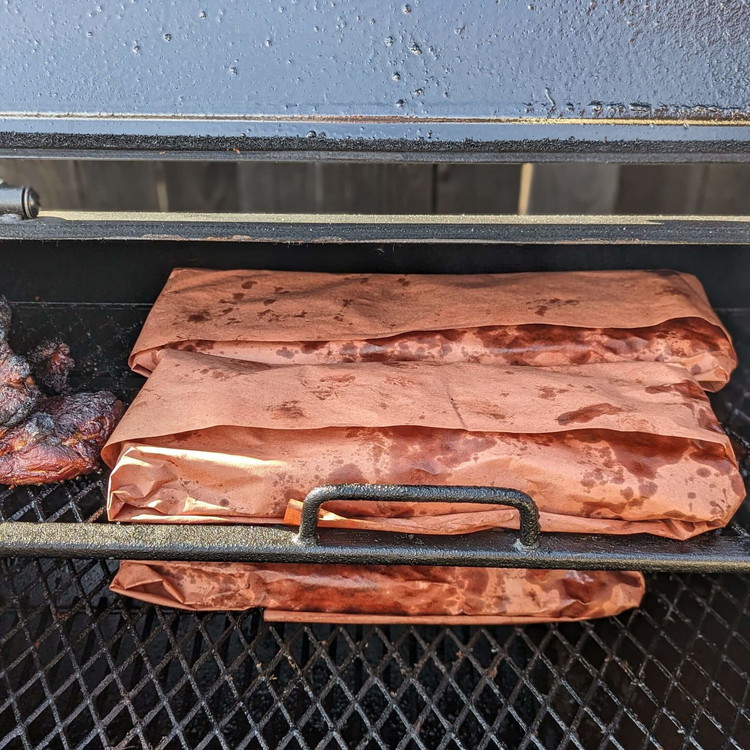 Image of Wrap the rib racks in butcher paper (or foil), spritzing the inside of the paper, and returning to the smoker for two more hours.