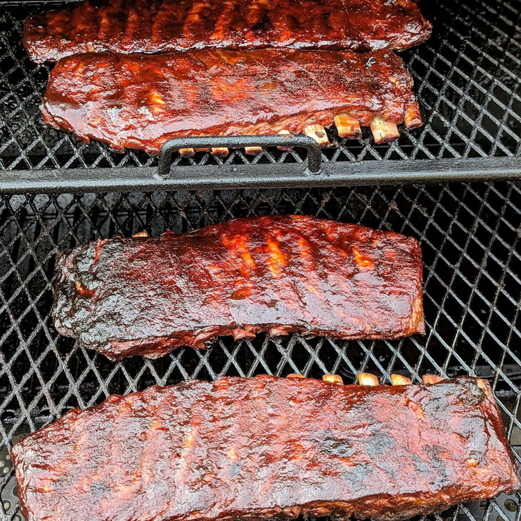 Image of Smoke the ribs (always bone side down) and riblet trimmings for three hours, spritzing with the spray bottle every hour.