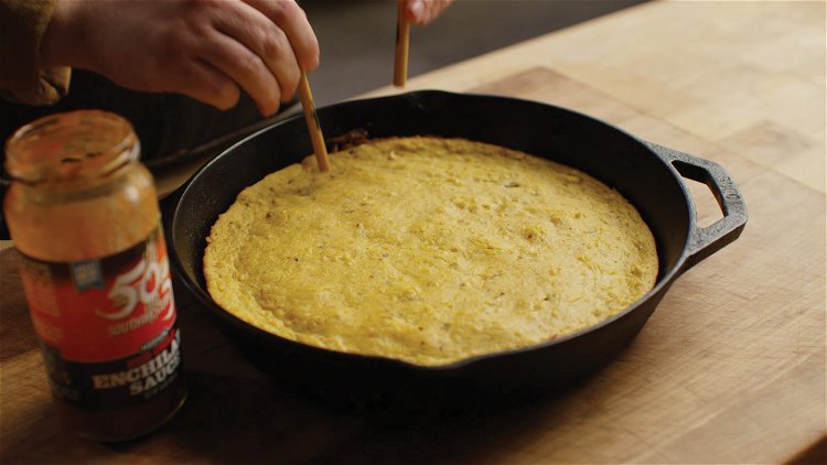 Image of Using chop sticks, poke holes in the cornbread. Pour one...