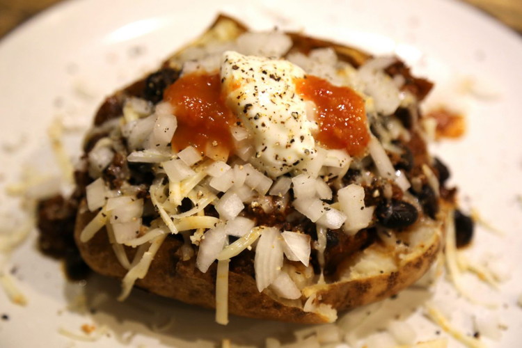 Image of Time to serve. Pictured is a baked potato with habanero jack cheese, white onion and my Smoked Mango Habanero Sauce!