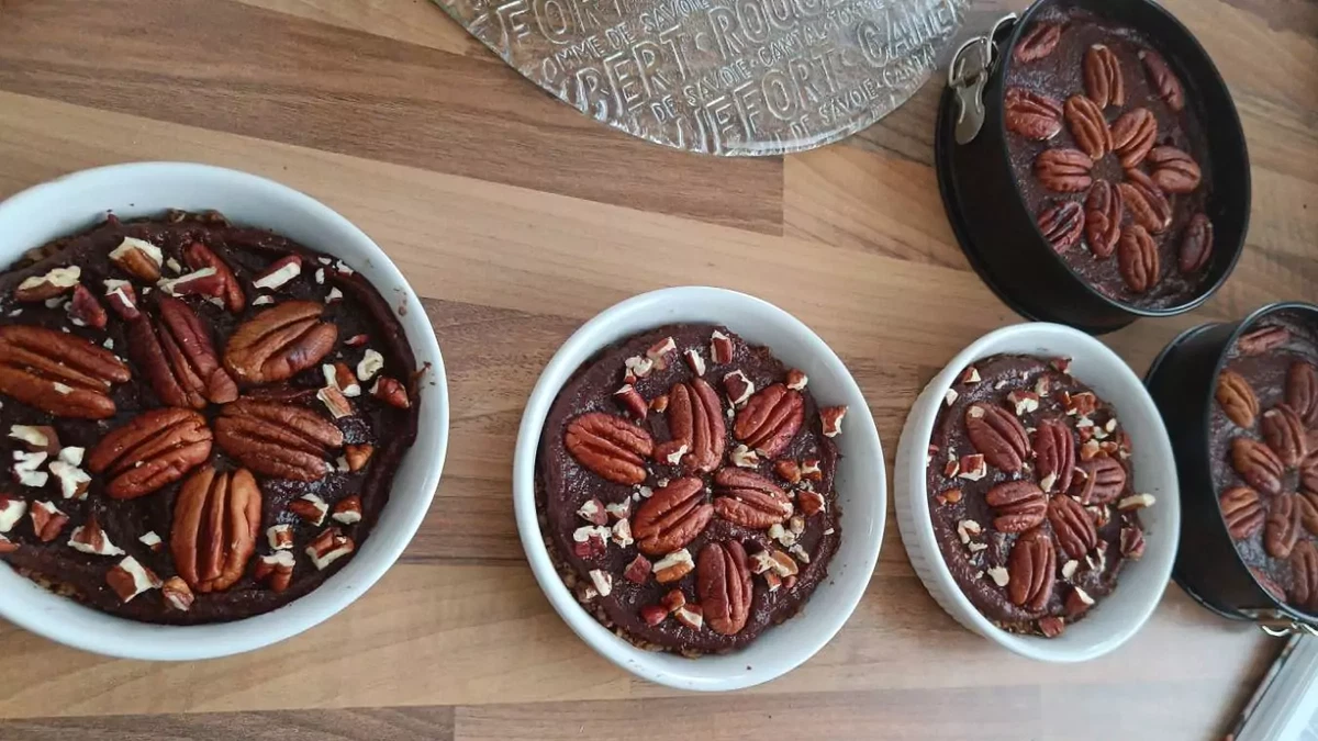 Pecan raw cake with lingonberry and spruce sprouts