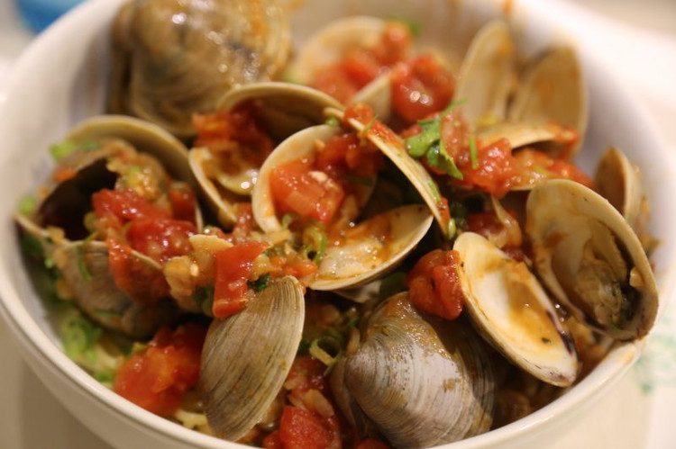 Image of Add the clams, the parsley and the scallions to the tomatoes and stir to coat everything. Toss any clam shells that have given up their meat.