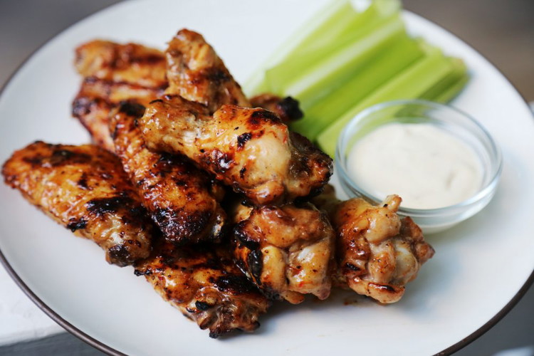 Image of In a clean large bowl, toss the wings with the sauce. Turn the heat up on the grill to medium high or lower your grate/add more coals if you’re over a fire, more heat is the goal. Use tongs to...