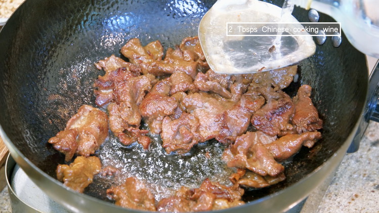 Image of Drizzle 2 Tbsps Chinese cooking wine from the side of the wok to help to deglaze the bottom.