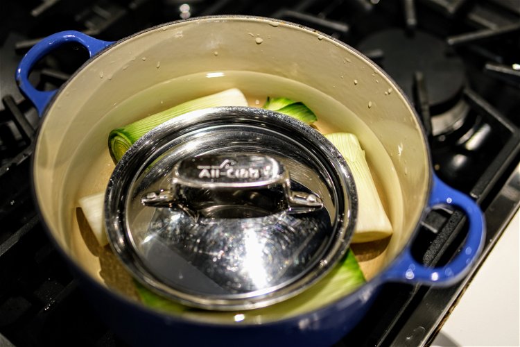 Image of Place a lid or some other weight over the leeks. ...