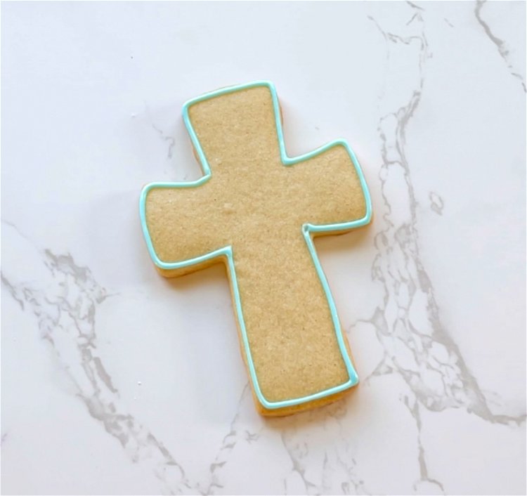Image of Outline the entire cross shape with blue outline consistency icing. 