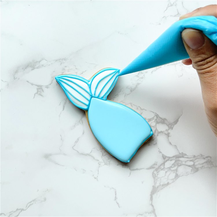 Image of To get precise lines, hold your piping bag over the cookie and let the icing fall into place. 
