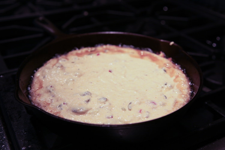 Image of Pour the batter into the hot bacon grease. The rubber spatula lets you scoop out your bowl cleanly. If needed, spread the batter out a bit in the pan to make it even. It should be sizzling, that is not...