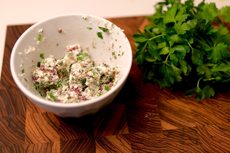 Image of While the eggplant roasts you can prepare the filling by breaking up the goat cheese with the back of a fork in a small bowl.  Once it is crumbly you can add olives, capers, and parsley and mix well. Set...