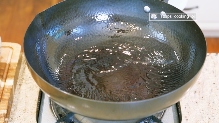 Image of Turn the heat to high and heat the wok until smoking hot. Add 2.5 Tbsps of oil and swirl it around to form a non-stick layer at the bottom.