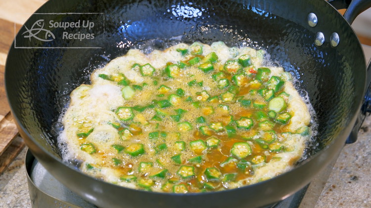 Image of Add the okra and egg mixture and wait for 10 seconds. Then gently swirl the wok around to make sure the bottom of the egg is not sticking to the metal.