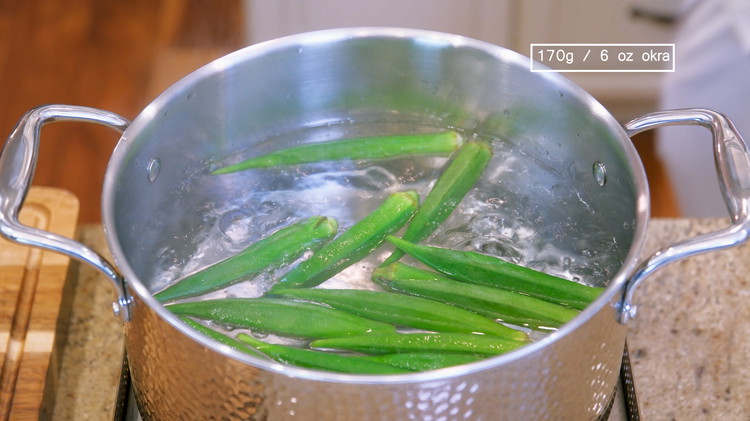 Image of Bring a pot of water to a boil, add oil and okra, and blanch for 1.5 minutes.  The oil will coat the surface of the okra and retain its vivid green color. 