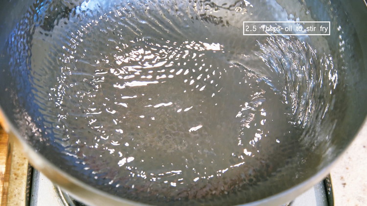 Image of Turn the heat to high and heat the wok until smoking hot. Add oil and swirl it around to coat the bottom.