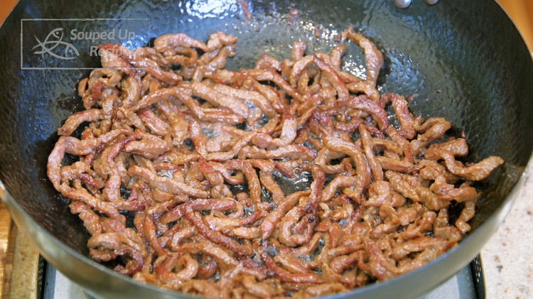 Image of Add the marinated beef and spread it out. Carefully loosen the strips so they don’t tangle together. Stir over high heat for 2 minutes or until nicely charred.