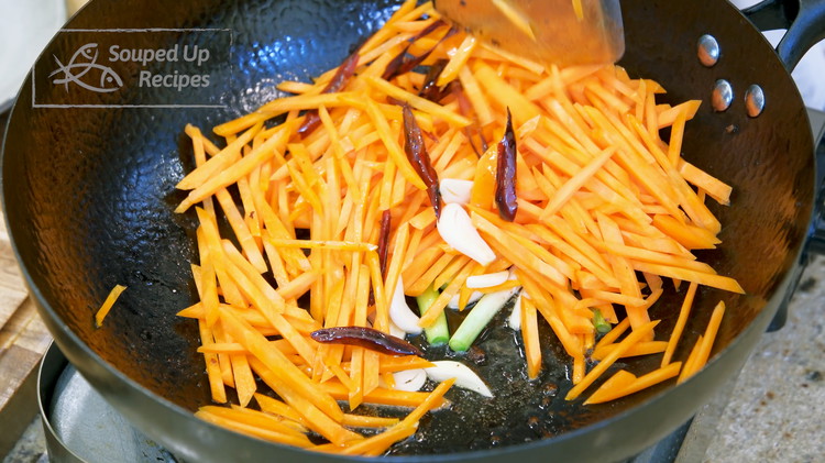 Image of Add the garlic, white part of the scallion, dried red chilies, and julienned carrots. Stir over medium heat for 3-4 minutes or until the carrots are slightly soft.