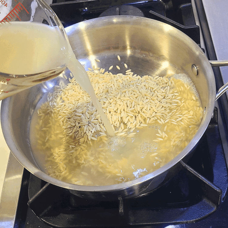 Image of Add the stock, orzo, salt, and pepper to a small pot over high heat and bring it to a boil