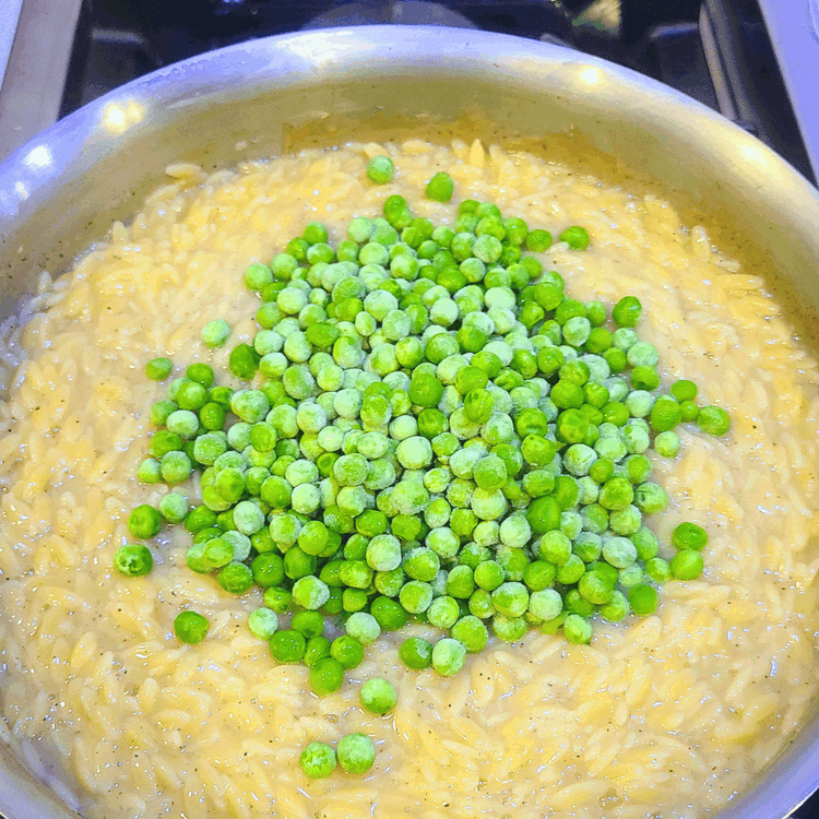 Image of Reduce the heat to medium, cover the pot, and cook the orzo for 10-12 minutes, until the pasta is tender and the liquid has been absorbed. When the liquid is almost gone, add in the peas to cook for about...