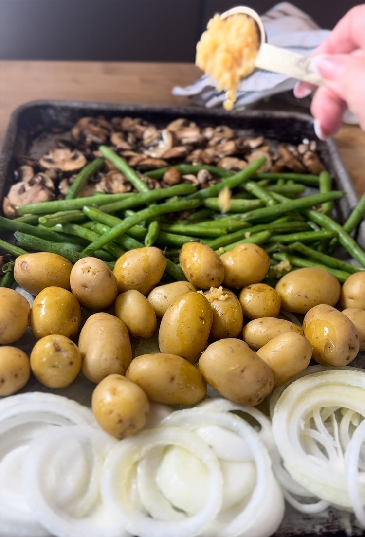 Image of sprinkle garlic across veggies.