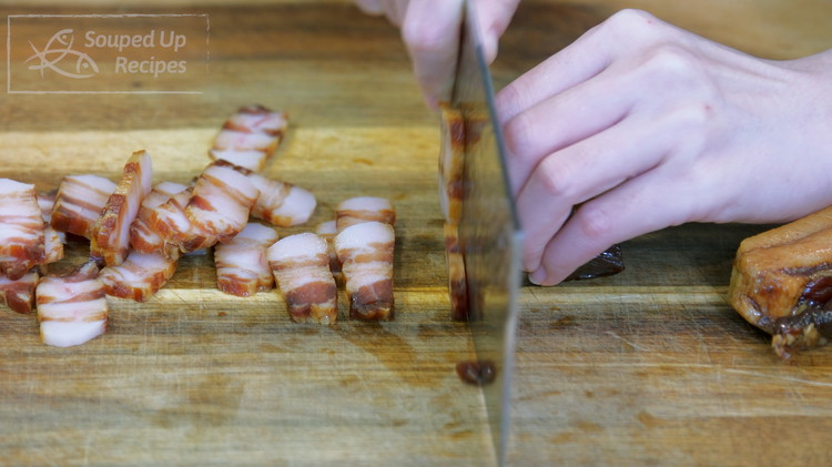 Image of Remove the tough skin from the Chinese cured bacon(AKA lap yuk), then slice the meat into thin slices. If you can find Chinese cured bacon, use thick cuts of regular bacon. It will be just as delicious. 