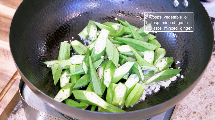 Image of Turn the heat to medium, and add 2 tbsp of oil, 1 tbsp of minced garlic, 1.5 tsp of minced ginger, and the okra. Stir for a few minutes or until the okra is a bit soft.