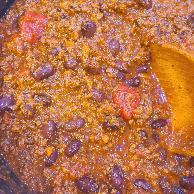 Image of Stir in the tomato paste, diced tomatoes with their juice, beans and cocoa powder. Stir well.