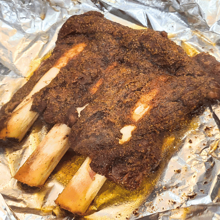 Image of Return to the Smoker: Place the wrapped ribs back on the smoker and continue cooking for an additional 2 hours. This helps tenderize the meat and infuse more flavor. After the wrap, the meat will be soft and pulling away...