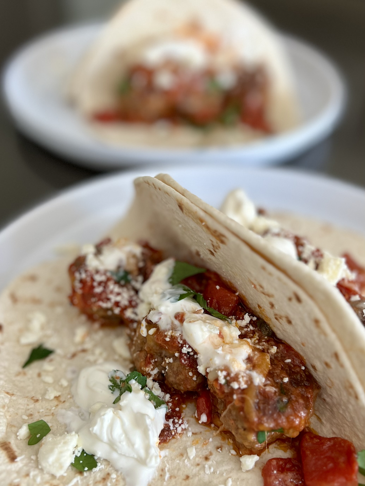 Image of Divide meatballs into tortillas, garnish with parsley or cilantro, and serve.