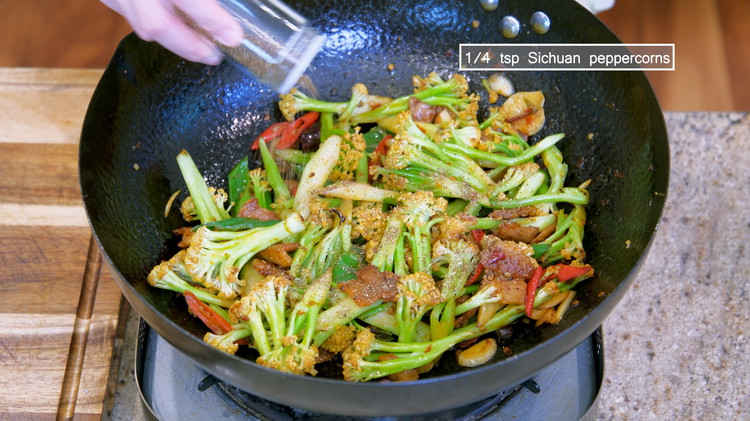 Image of Introduce the cauliflower back into the wok and stir well. Season it with soy sauce, oyster sauce, and Sichuan peppercorn powder and mix thoroughly. Serve as a side dish.