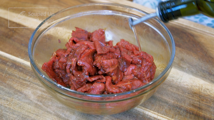 Image of Add a drizzle of cooking oil and mix to coat the beef. This will separate the meat slices so they don’t stick together when stir-frying. Let it sit for 15 minutes.