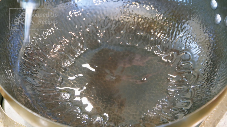 Image of Turn the heat to high and heat the wok until smoking hot. Add a drizzle of oil and swirl it around. High heat helps the oil to form a non-stick layer at the bottom of the wok.