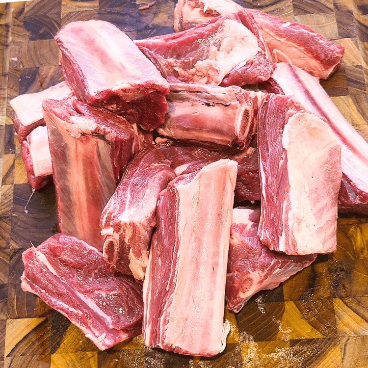 Image of Prep the ribs by slicing into sections between the bones and season with salt and pepper.