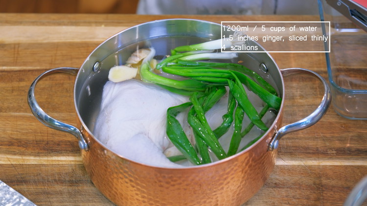 Image of Add the chicken, 5 cups of water, 4 scallions, and ginger slices to a stock pot and bring it to a boil over medium heat. I used a piece of boneless chicken breast and two chicken leg quarters. You can use one of the cuts if you want....