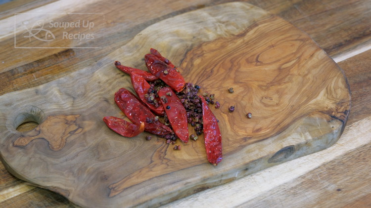 Image of Remove the chilies from the saucepan, but leave the oil behind. Let the chili and Sichuan peppercorns cool on the cutting board.