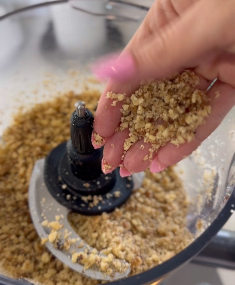 Image of In a food processor finely chop nuts to the size...