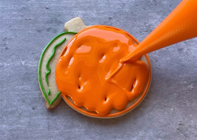 Image of Flood the round orange section with your orange flood consistency icing. 