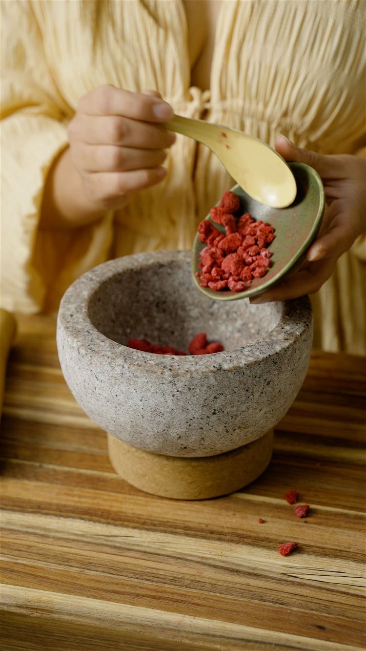 Image of Add the freeze dried raspberries to your mortar and crush....