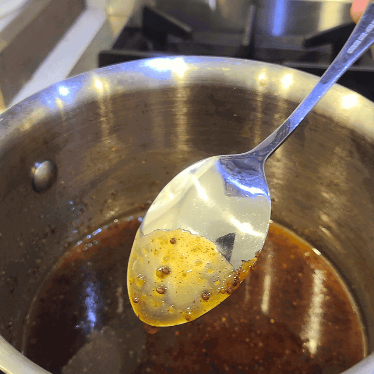Image of Bring the mixture to a boil, then reduce the heat to medium-low and simmer until the glaze is reduced by about half and starts to thicken. It will stick to the back of a spoon when it is ready.